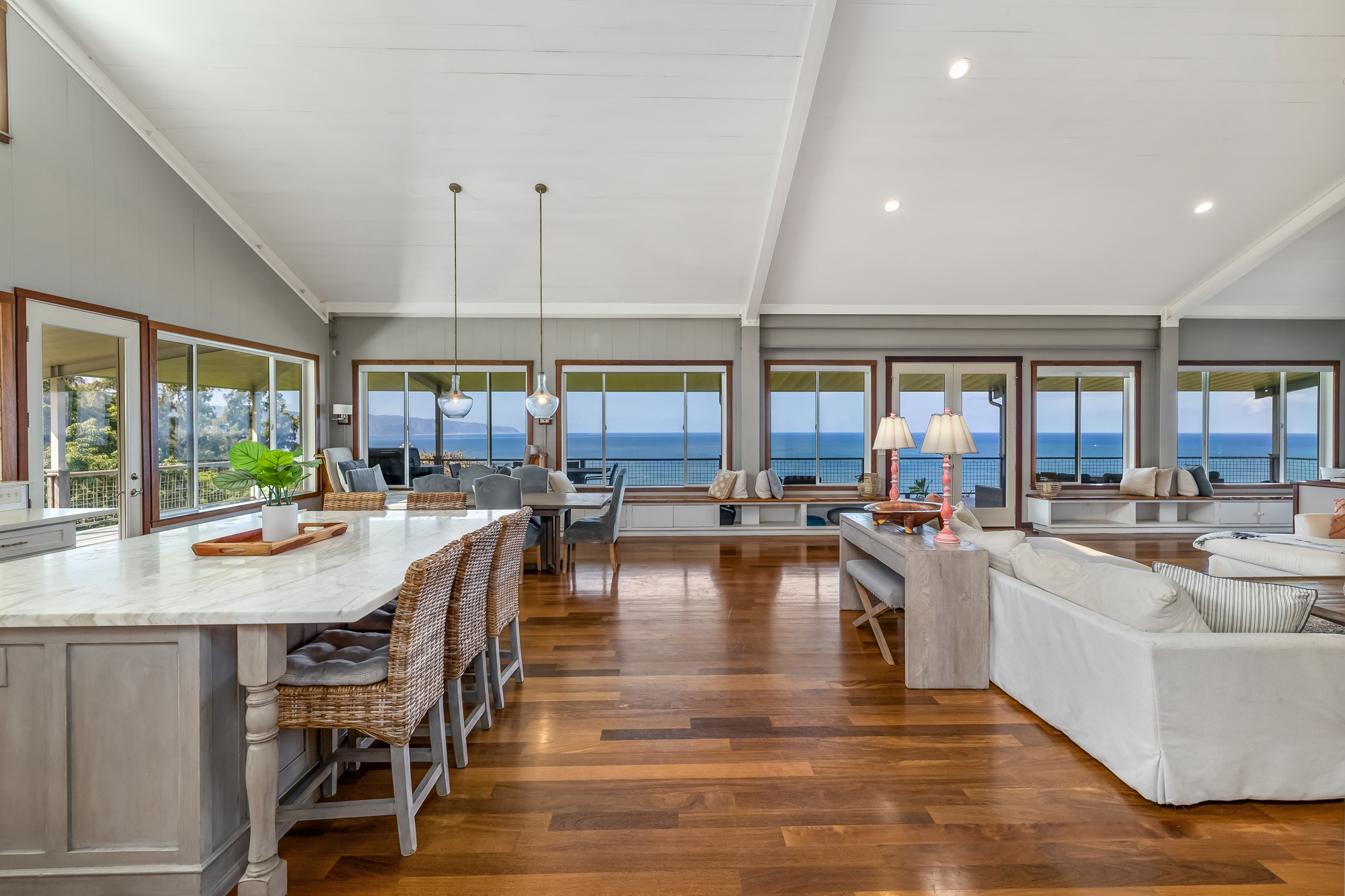 Open-concept living room inside Whale House with floor-to-ceiling ocean views on North Shore Oahu